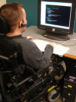 boy in wheelchair at computer with headphones